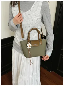 Green brown shoulder bag detail view, casual crossbody handbag with cute floral pendant.