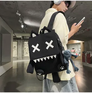 Stylish black cartoon monster backpack with cute cat ears and X eyes detail for daily travel.