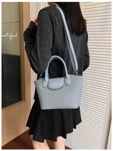 Stylish light blue shoulder bag for women, casual crossbody tote with top handle and strap.