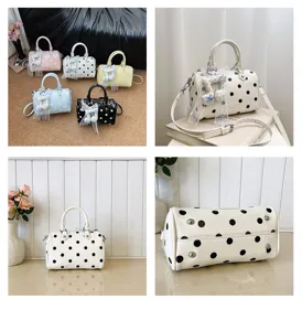 Detailed view of women polka dot shoulder boston bag with cute music note pendant charm.