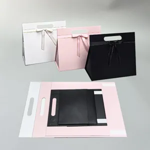 Foldable gift boxes with ribbon closures in white, pink, and black for parties and weddings.