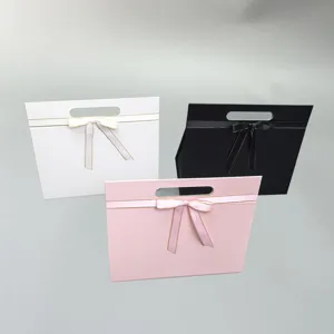 Close-up detail of foldable gift boxes featuring elegant bow knots and convenient carrying handles.