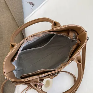 Detail view of a retro brown women handbag interior, featuring zipper pocket and lining.