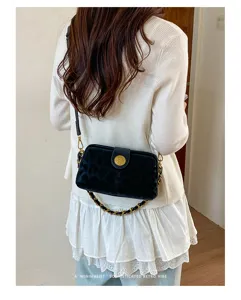 Nahaufnahme der schwarzen Samtkette Umhängetasche mit Retro-Goldverschluss und feinen Details.