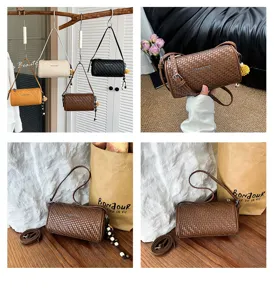 Gevlochten cilinder schoudertas met metalen plaat en fijne riemdetails, trendy chique.