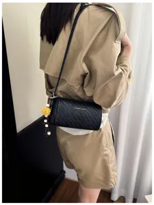 Zwarte geweven schouder-kussentas voor dames, stijlvolle crossbody tas met bloemenhanger.