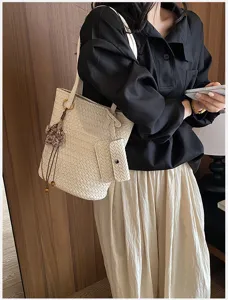 Detailed view of the elegant woven shoulder tote bag showcasing exquisite texture and attached pouch.
