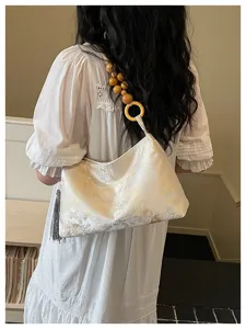 Detail of new Chinese style shoulder underarm bag with wooden bead strap and tassel.