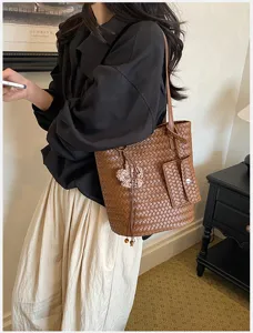 Brown woven tote bag for women, stylish leather-texture shoulder bag with small front pocket.