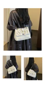 Vue détaillée d'un sac porté épaule plissé blanc avec chaîne en métal et fermoir rotatif.