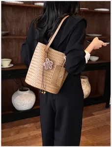 Woven tote bag detail view, minimalist brown shoulder bag with elegant woven pattern.