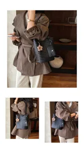 Detailed view of women's black woven leather tote shoulder bag with flower charm and front pocket.