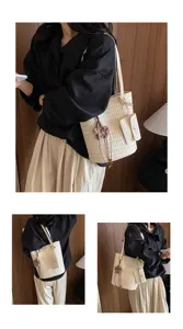 Detailed view of women woven tote shoulder bag with flower pendant, casual commuting style.