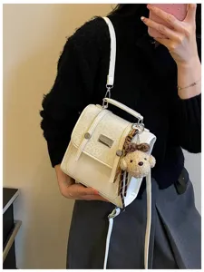 Chic white mini backpack with cute bear pendant, stylish college commuter crossbody bag.