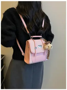 Chic pink mini backpack for women, cute preppy style PU leather school bag with puppy plush charm.