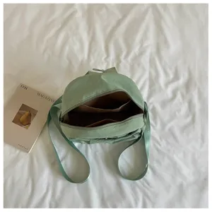 Light green minimalist nylon casual backpack interior detail view with storage compartments