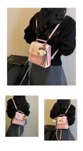 Stylish pink college style backpack for women, cute bear pendant, casual commuter bag.