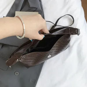 Dark brown woven leather shoulder bag interior and texture detail shot showing strap.