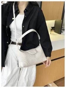Detailed view of a chic cream white woven underarm bag, elegant shoulder strap design.