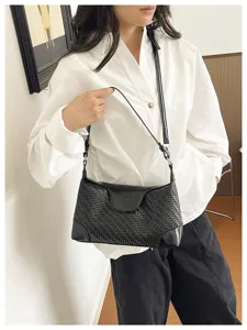 Detailed view of women's black woven underarm shoulder bag, stylish commuter handbag.