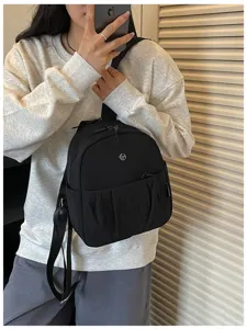 Close-up detail shot of women's minimalist black backpack, daily commuter style and casual design.