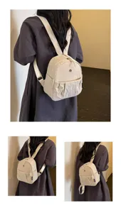 Detail view of the minimalist beige mini backpack, showing its compact shape and pocket design.