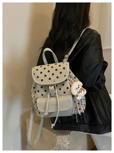 Stylish white backpack with black polka dots, featuring a front pocket and puppy charm.