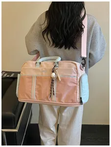 Detailed shot of the pink travel duffle bag showcasing large capacity and baseball charm.