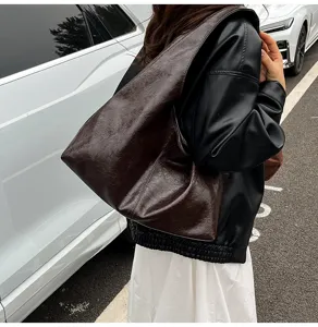 Dettaglio borsa a spalla in pelle cerata marrone scuro, borsa tote vintage donna per lavoro.