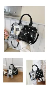 Black polka dot pillow bag detail with white lace note pendant, elegant shoulder crossbody design.