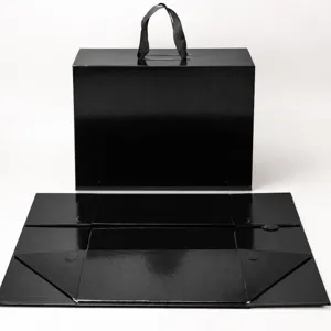 Boîte cadeau pliante noire avec poignée et fermeture aimantée, design à cinq panneaux.