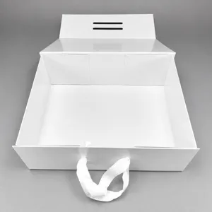 Boîte cadeau pliante blanche avec poignée en ruban et fermeture aimantée de haute qualité.