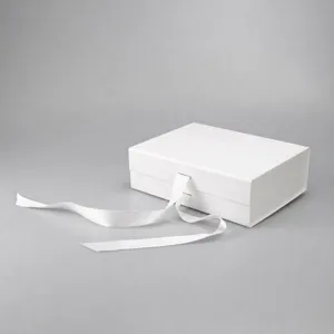 White folding gift box detail showing the clean cardboard finish and elegant ribbon closure.