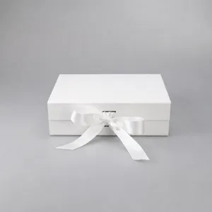 White folding gift box detail showing the elegant satin ribbon bow and clean finish.