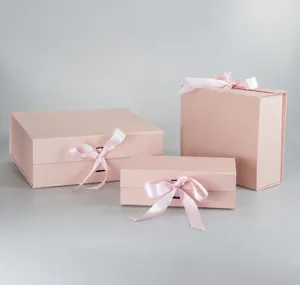 Pink foldable gift boxes with ribbon closures detail view, perfect for apparel and clothing packaging.