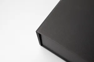 Black luxury gift box corner detail, premium textured folding box for packaging presentation.