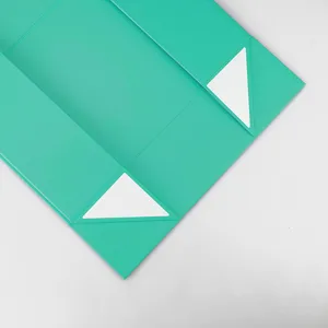 Détail de boîte cadeau pliante cyan montrant la structure magnétique et les bandes adhésives.