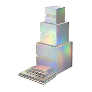 Vue detaillee de boites cadeaux magnetiques pliables avec finition laser holographique empilees.
