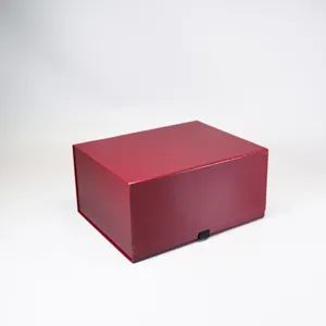 Gros plan du coffret cadeau pliable rouge foncé montrant sa texture lisse et sa fermeture aimantée.