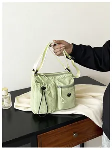 Nylon shoulder crossbody bag detail, casual daily commuter style, multi-pocket design.