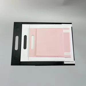 Detailansicht verschachtelter Geschenkkartons in Schwarz, Weiß und Rosa mit Griff.