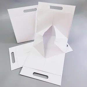 Vue détaillée de la boîte cadeau pliante blanche avec poignée, emballage en papier pour produits.