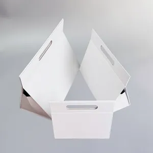Vue détaillée de la boîte cadeau triangle pliable blanche avec poignée pratique.