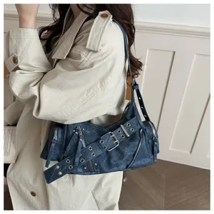Vista dettagliata della borsa a tracolla da moto in denim blu scuro con zip e fibbie metalliche.