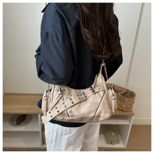 Primo piano dettagliato della borsa a tracolla stile moto con fibbie metalliche e tasche con zip.