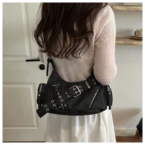 Vista dettagliata di una elegante borsa a tracolla nera in stile punk con fibbie e zip metalliche.