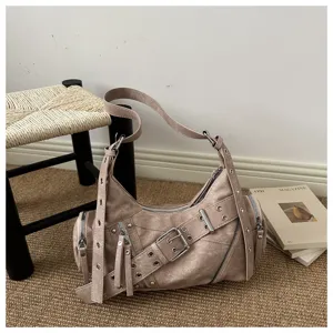 Dettaglio di una borsa a tracolla stile punk con fibbie metalliche e dettagli con cerniera.