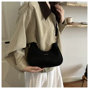 Dettaglio ravvicinato di una borsa a tracolla hobo nera minimalista con dettaglio dorato.