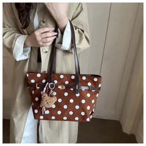 Dettaglio della borsa tote rétro in camoscio a pois marroni con minuteria fine e grazioso ciondolo.