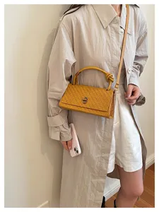 Chic woven shoulder bag detail showcasing premium texture, elegant handle and metal clasp.